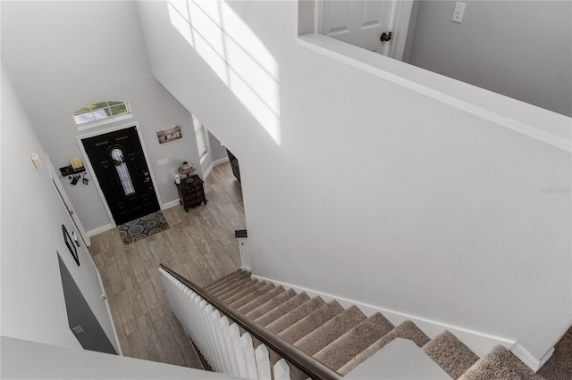 entrance foyer featuring stairway, wood finished floors, baseboards, and a towering ceiling