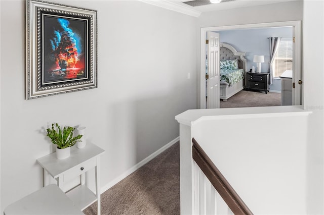 corridor with baseboards, an upstairs landing, carpet flooring, and crown molding