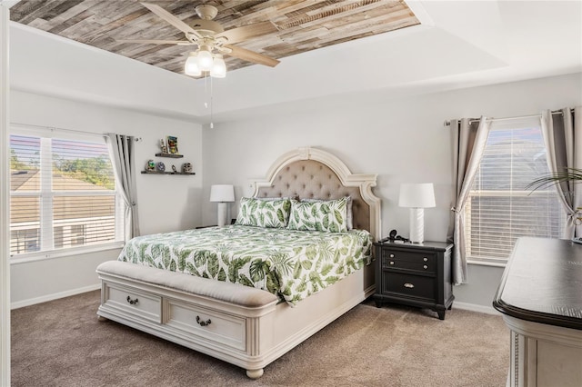 bedroom featuring wood ceiling, a tray ceiling, carpet floors, and baseboards