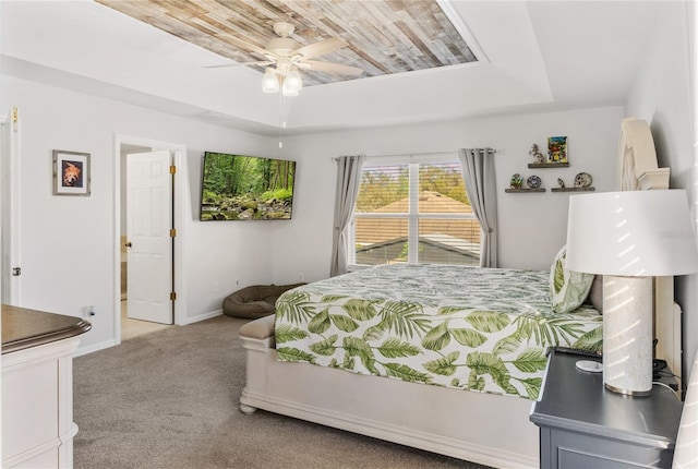 carpeted bedroom featuring baseboards, a raised ceiling, a ceiling fan, and access to outside