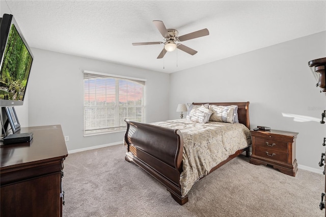 carpeted bedroom featuring baseboards, a textured ceiling, and a ceiling fan