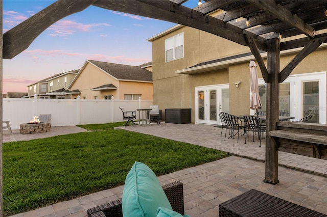 exterior space featuring a lawn, a pergola, fence, french doors, and a fire pit