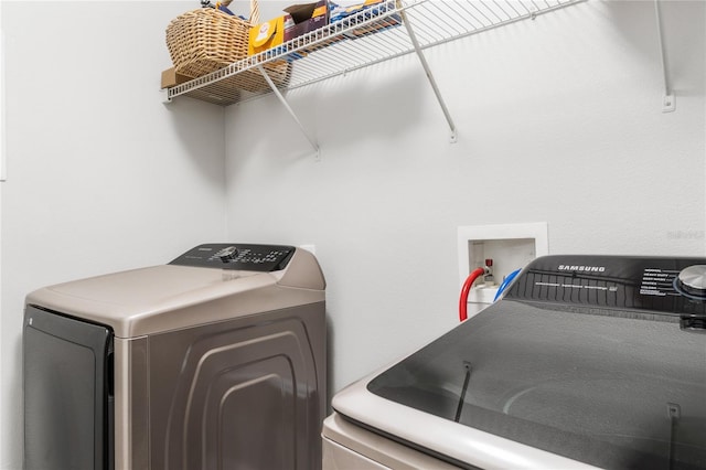 washroom with independent washer and dryer and laundry area