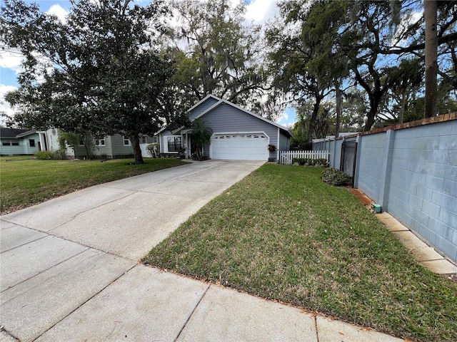 view of front of house with a front yard, driveway, an attached garage, and fence