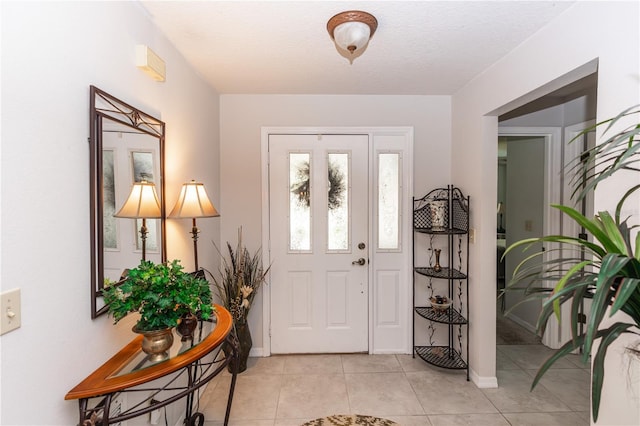 foyer with light tile patterned floors and baseboards