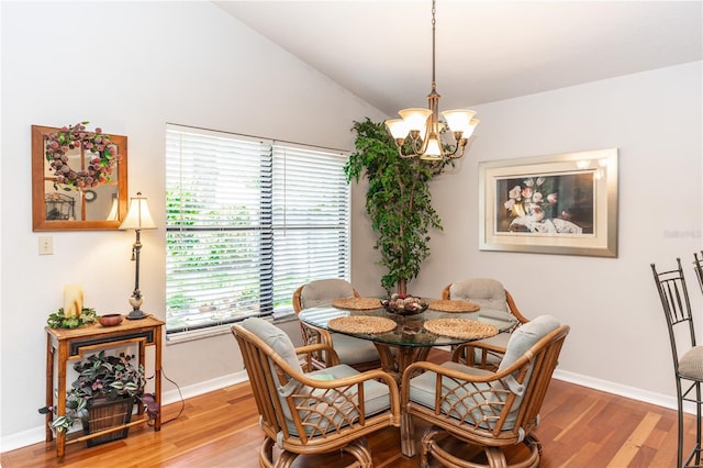 dining room with a chandelier, light wood-type flooring, baseboards, and vaulted ceiling