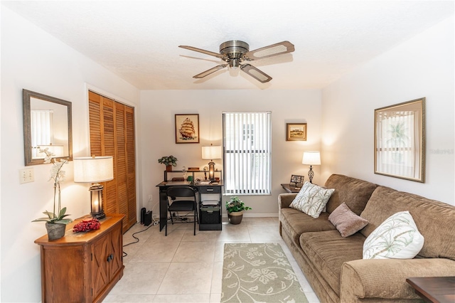 living room featuring light tile patterned floors, a ceiling fan, and baseboards