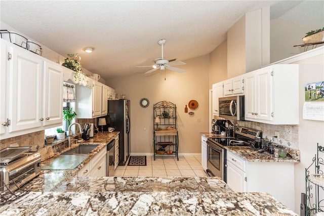 kitchen featuring a ceiling fan, lofted ceiling, stone countertops, a sink, and stainless steel appliances