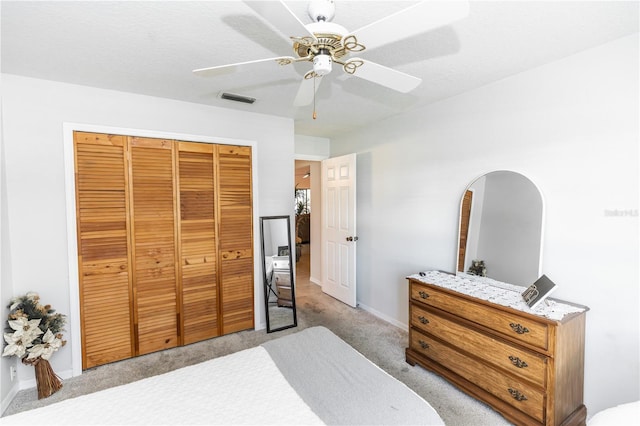 carpeted bedroom with visible vents, a closet, arched walkways, baseboards, and ceiling fan