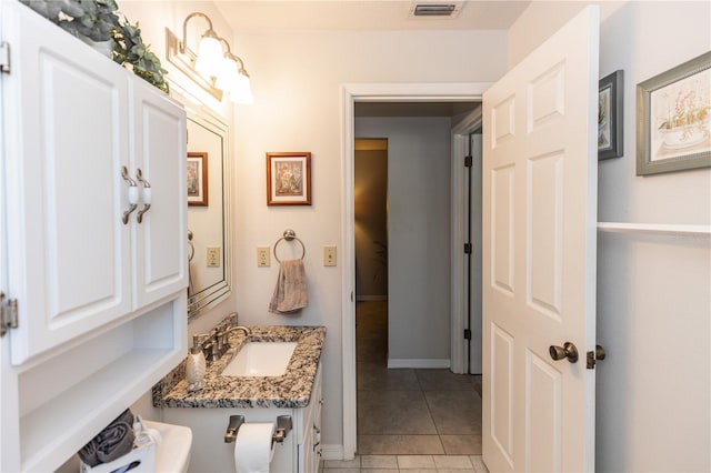 bathroom with a sink, visible vents, baseboards, and tile patterned floors