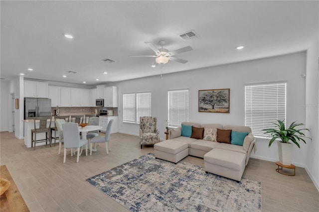 living room with light wood-style flooring, recessed lighting, visible vents, and a ceiling fan