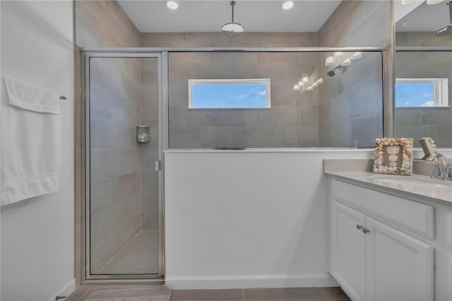 bathroom featuring recessed lighting, a shower stall, a wealth of natural light, and vanity