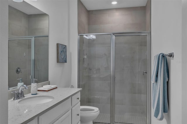 full bathroom featuring toilet, a shower stall, and vanity