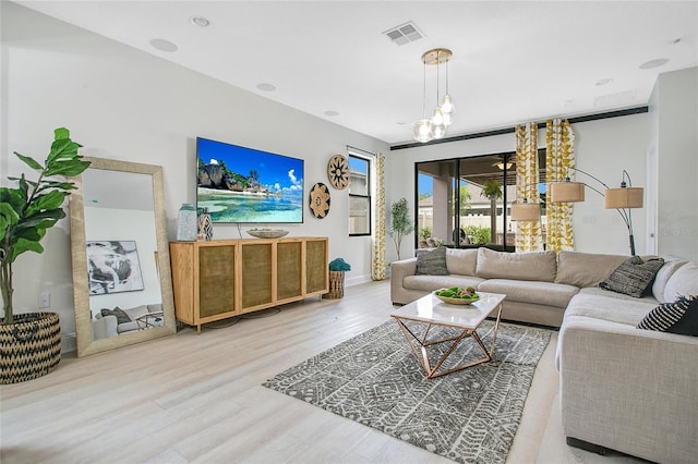 living area featuring visible vents and wood finished floors