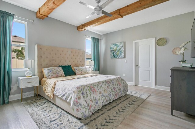 bedroom featuring baseboards, beamed ceiling, and wood finished floors