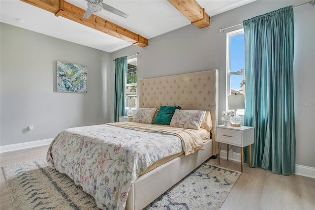 bedroom featuring beam ceiling, ceiling fan, baseboards, and wood finished floors