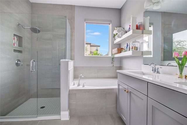 bathroom featuring a stall shower, a garden tub, vanity, and tile patterned floors