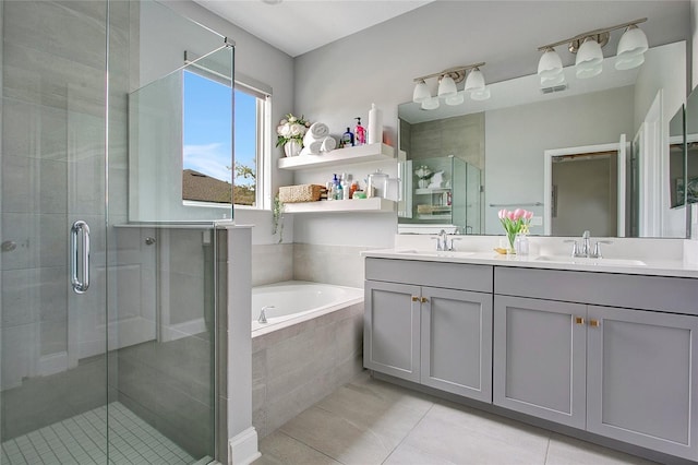 full bath with a bath, a shower stall, double vanity, and a sink