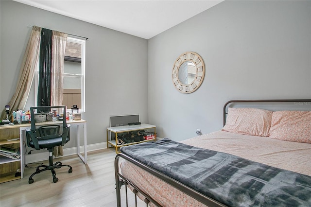 bedroom featuring light wood-type flooring and baseboards