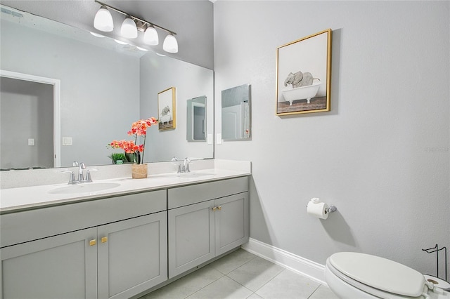 full bathroom featuring double vanity, a sink, toilet, and tile patterned floors