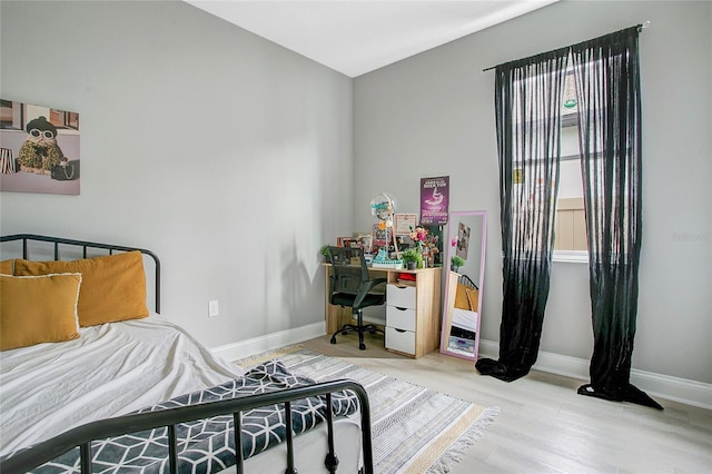 bedroom featuring baseboards and wood finished floors