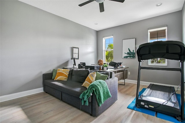 interior space with a ceiling fan, baseboards, and wood finished floors