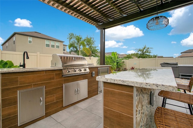 view of patio / terrace with an outdoor kitchen, a fenced backyard, area for grilling, and a sink