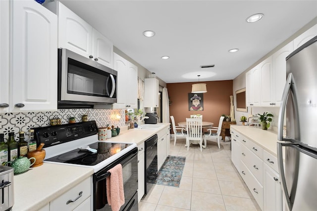 kitchen featuring light tile patterned floors, appliances with stainless steel finishes, decorative backsplash, and white cabinets