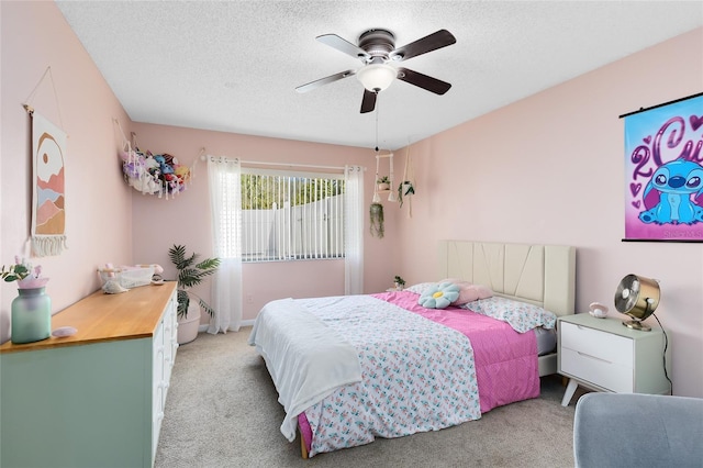 bedroom featuring a textured ceiling, a ceiling fan, and light colored carpet