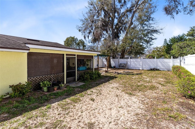 view of yard featuring a sunroom and a fenced backyard