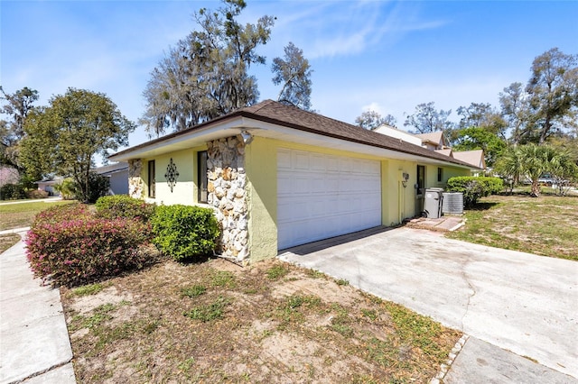 single story home featuring a garage, driveway, and stucco siding