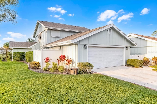 view of front facade featuring a front yard, an attached garage, driveway, and roof with shingles