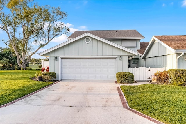 view of front of home featuring a gate, driveway, roof with shingles, a front lawn, and a garage