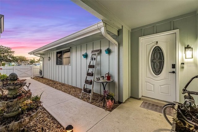 entrance to property featuring fence and board and batten siding