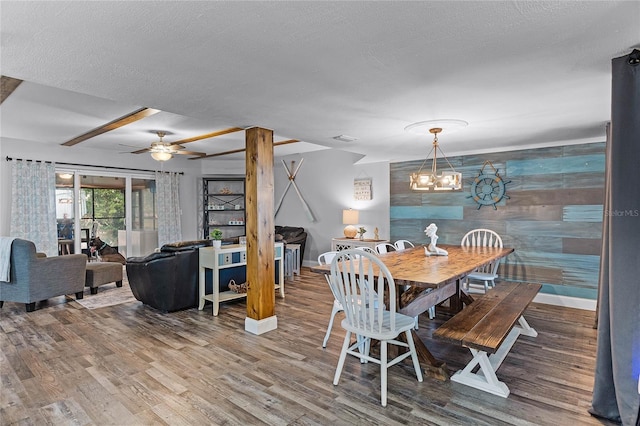 dining room featuring a textured ceiling, baseboards, and wood finished floors