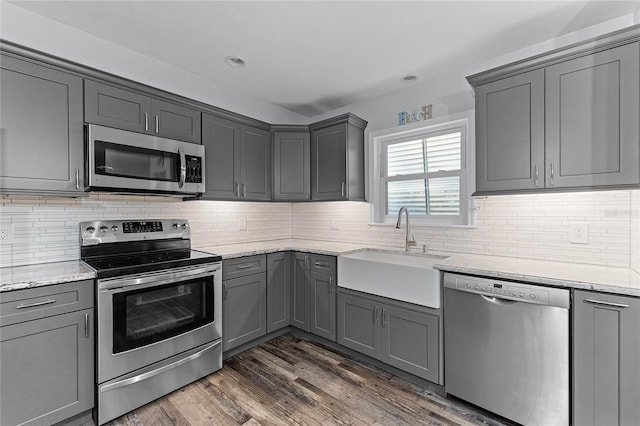 kitchen with a sink, appliances with stainless steel finishes, and gray cabinetry