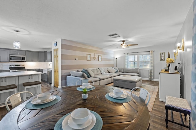 dining space featuring dark wood-style floors, visible vents, baseboards, and ceiling fan