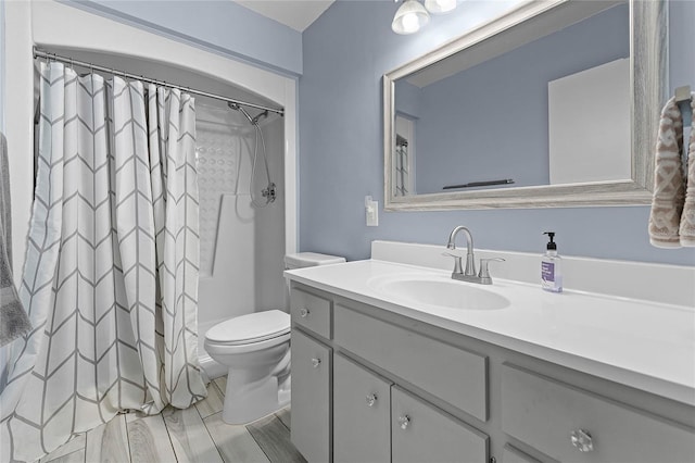 full bath with vanity, a shower with shower curtain, and toilet
