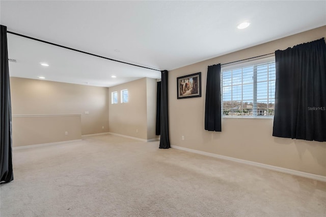 spare room featuring baseboards, recessed lighting, and light colored carpet