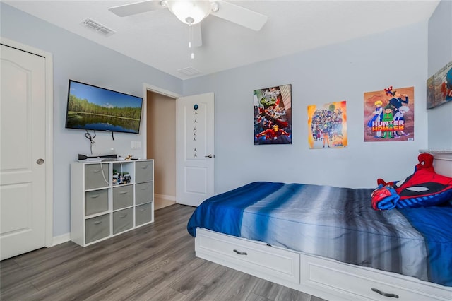 bedroom with baseboards, wood finished floors, visible vents, and a ceiling fan