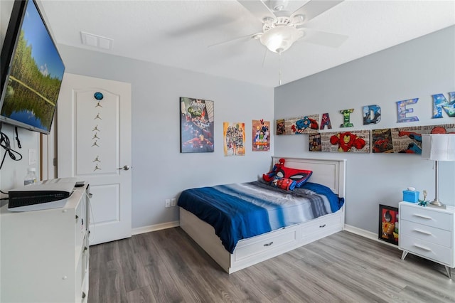 bedroom with ceiling fan, wood finished floors, visible vents, and baseboards