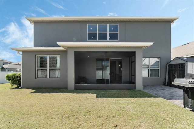 back of property featuring a sunroom, a yard, a patio, and stucco siding