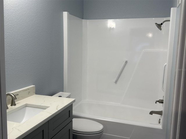 bathroom featuring vanity, shower / bathing tub combination, toilet, and a textured wall