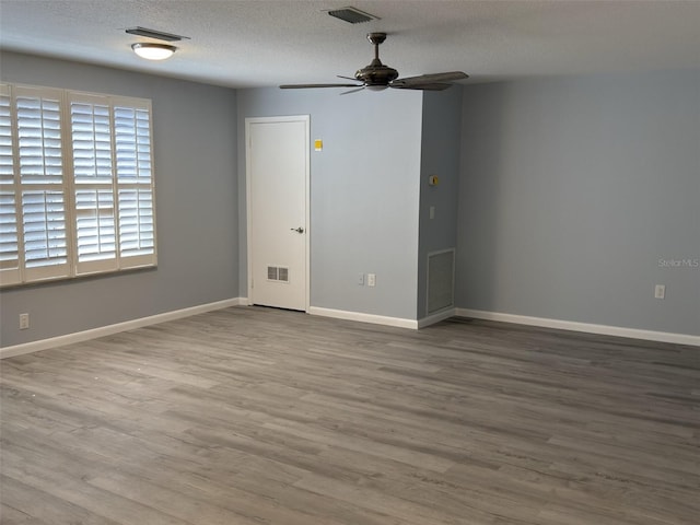 unfurnished room featuring visible vents, a textured ceiling, and wood finished floors