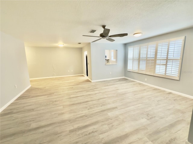 spare room with visible vents, baseboards, and wood finished floors