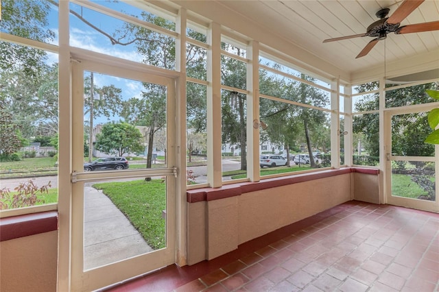 unfurnished sunroom with wood ceiling and ceiling fan