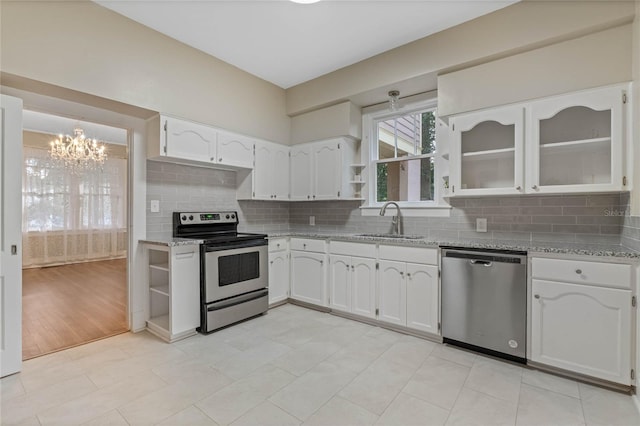 kitchen featuring white cabinets, appliances with stainless steel finishes, open shelves, and a sink