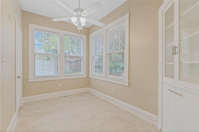 empty room featuring visible vents, baseboards, and a ceiling fan