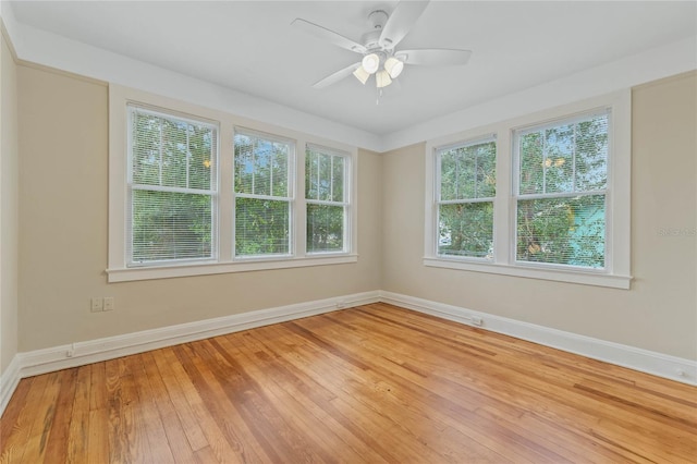 empty room with baseboards, ceiling fan, and hardwood / wood-style floors