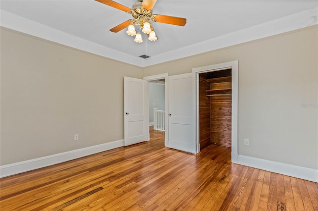 unfurnished bedroom with ceiling fan, light wood-style flooring, and baseboards